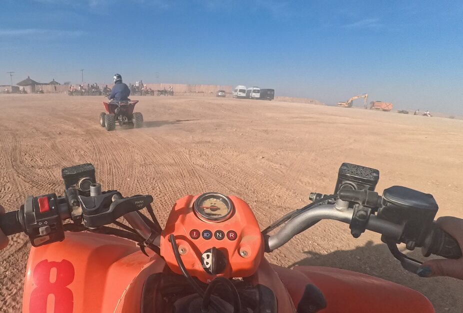 アガファイ砂漠でクアッドバイクに乗って走っている様子。ハンドル越しに砂漠が広がる