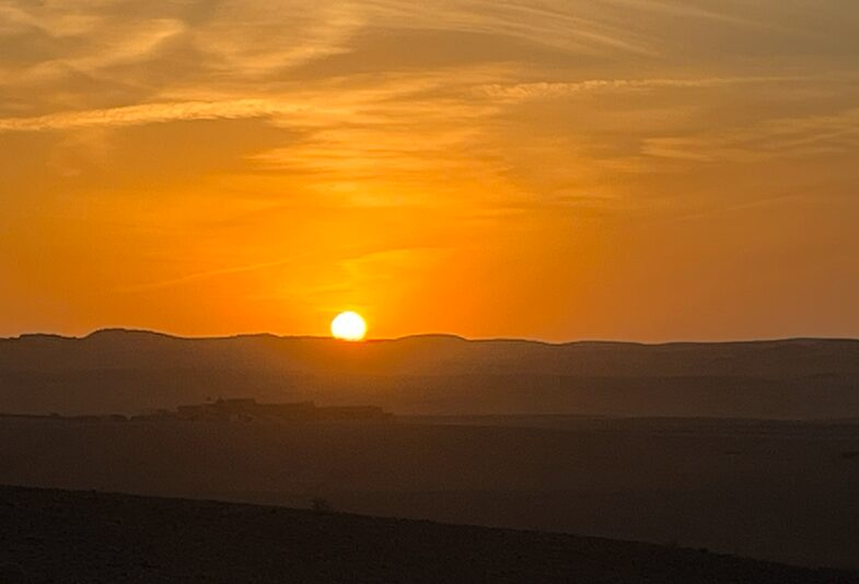 アガファイ砂漠で見た夕日。地平線に沈む太陽とオレンジ色の空