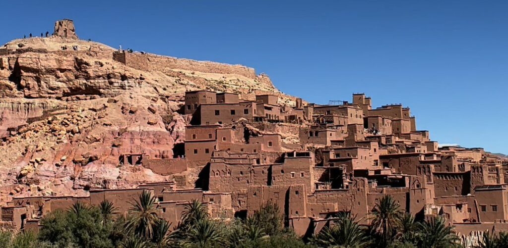 対岸から見たアイット・ベン・ハドゥの集落全景。赤茶色の土で作られた建物が丘の斜面に連なっている様子